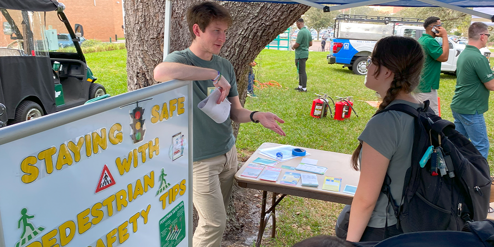 Two students talking under a tent