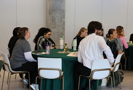 People sitting at table and turned to listen to speaker