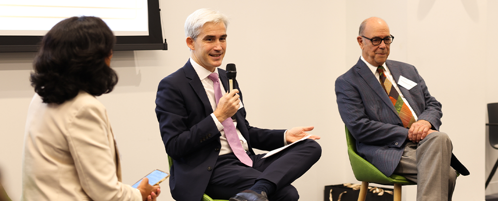 Three speakers sitting in green chairs