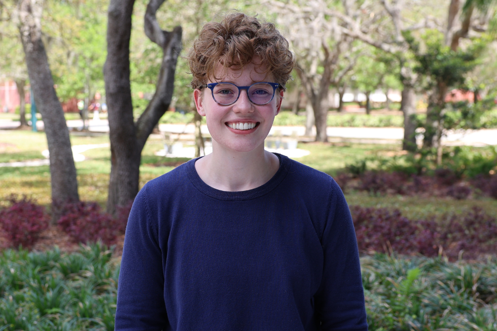 Gray Zeisse headshot outside in front of trees