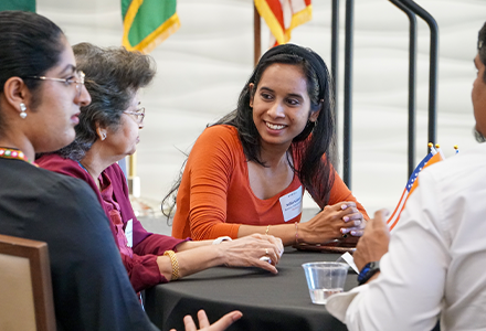 student talking to alumnia at a table