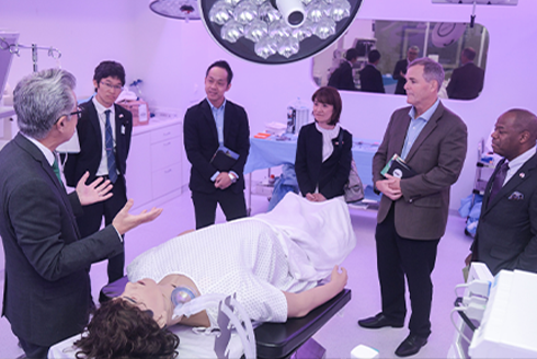 People standing beside a medical dummy