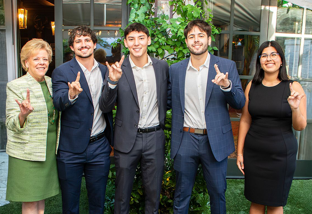 students with USF President Rhea Law holding up hands in "bulls" sign