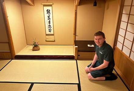 Schrader kneeling in a tan room