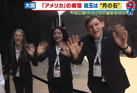 Japanese news snapshot of Schrader and others smiling and waving