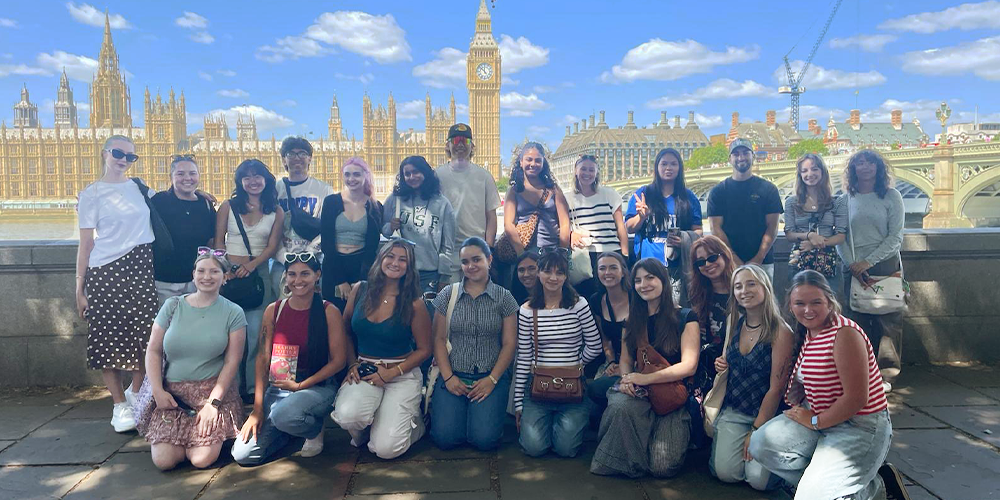 Students smiling in front of a large building