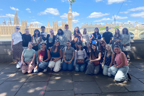 Students smiling in front of a large building