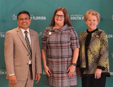 USF Provost Prasant Mohapatra, Professor Judithanne Scourfield McLauchlan, and President Rhea Law pose in front of a University of South Florida step and repeat