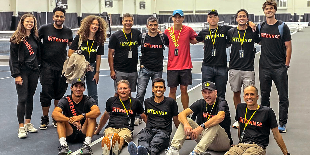 group of athletes smiling with yellow lanyards
