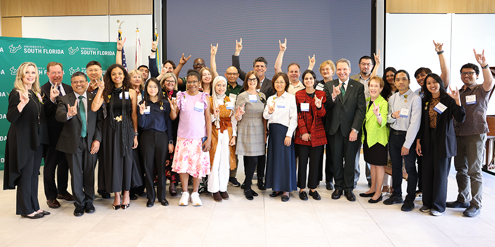 Group of people smiling and holding up "go bulls" hand signs