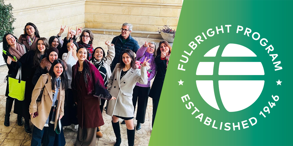 group smiling with fulbright ebmlem on right panel