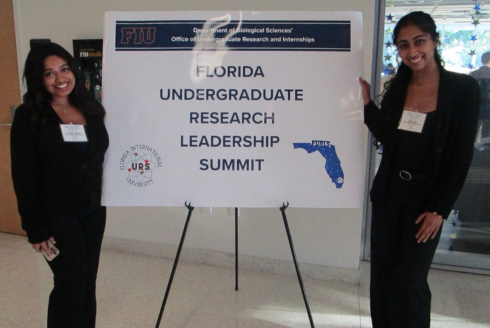 Sirinandini Amperayani and Sakshi Wagh in front of a poster board of research