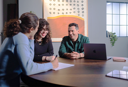 people smiling and looking at paper