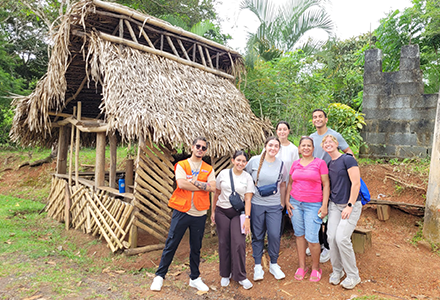 People standing outside of a wooden hut
