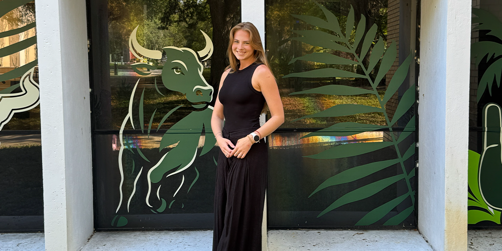 Anne Nobrega standing in front of her USF decals