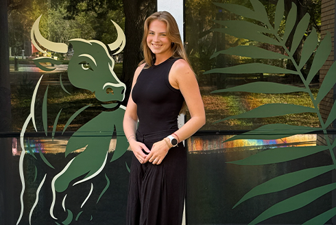 Anne Nobrega standing in front of her USF decals