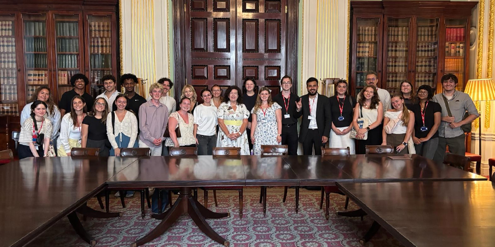 A group of smiling people in an ornate room