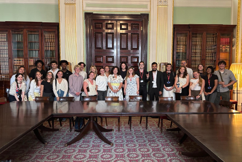 A group of smiling people in an ornate room