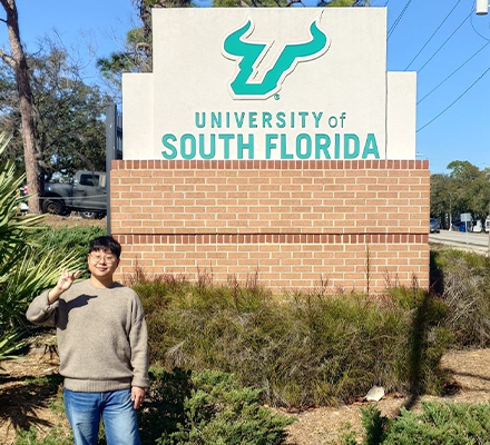 person standing in front of USF sign