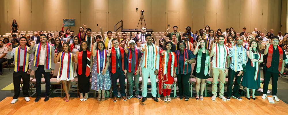 international students smiling and holding up "go bulls" hand signs