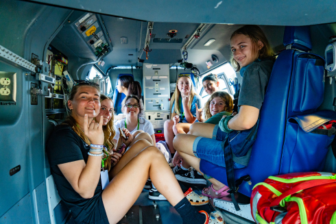 Students from Disaster Management Camp smiling from inside a helicopter.